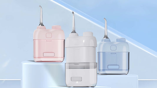 Three Orateeth Smart Mini Water Flossers in pink, white, and blue, displayed on a modern light blue background, highlighting their compact and portable design for gentle oral care, braces, and sensitive gums.
